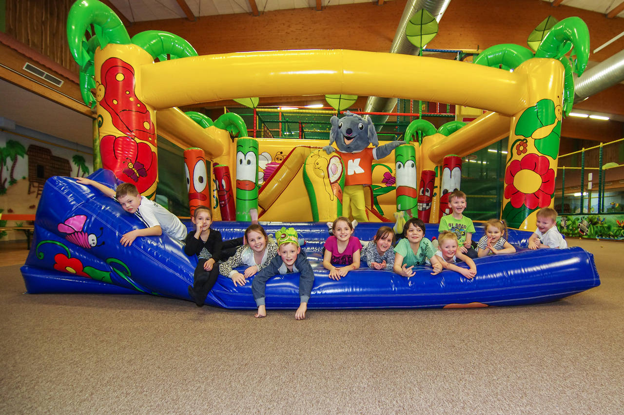 Kinder liegen auf der Hüpfburg